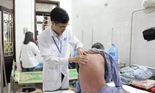 Các BS khẳng định, không thể chữa khỏi hẳn bệnh vẩy nến như quảng cáo tràn lan trên mạng. Ảnh: BS khám cho bệnh nhân bị vảy nến tại BV Da liễu TƯ