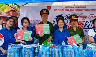 Cán bộ công an cài định danh điện tử cho phụ huynh đưa con đi thi