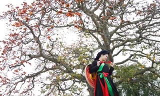 Một du khách mặc áo chị hai quan họ chụp ảnh bên cây gạo Lãnh Sơn. Ảnh: Nguyễn Thắng