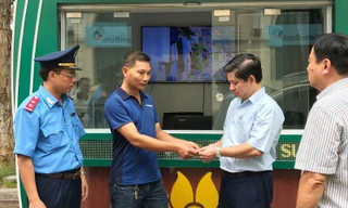 Đại diện Đội TTGT quận Ba Đình chứng kiến tài xế vi phạm trao tiền thu cao trả lại hành khách ​