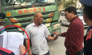 Tài xế vừa trình "lệnh bài" (văn bản chấp thuận của Sở GTVT-vòng tròn đỏ) vừa đưa điện thoại cho lực lượng chức năng nói chuyện với người ở đầu dây bên kia. Với sự chứng kiên của phóng viên, đại diện Thanh tra giao thông Hà Nội đã từ chối nghe.