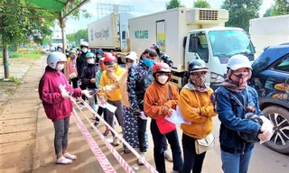 Đoàn người xếp hàng khai báo y tế khi qua địa phận Cư Jút (Đắk Nông)