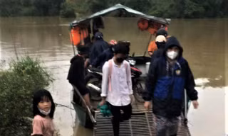 Lực lượng chức năng dùng thuyền máy đưa người dân qua lòng hồ an toàn