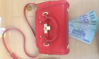 Chiếc túi xách và tiền mặt được cảnh sát trả cho bị hại. Ảnh: Quốc Thắng.