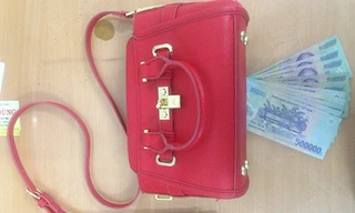 Chiếc túi xách và tiền mặt được cảnh sát trả cho bị hại. Ảnh: Quốc Thắng.