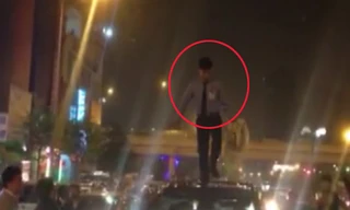 Nam thanh niên đứng trên nóc ôtô nhảy nhót. Ảnh cắt từ clip