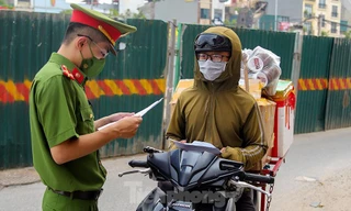 Lực lượng chức năng kiểm tra giấy tờ của shipper giao hàng trong thời gian Hà Nội giãn cách (Ảnh: Hoàng Mạnh Thắng)