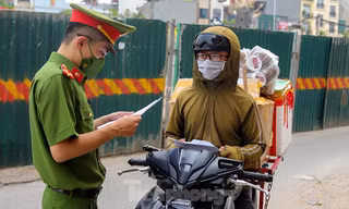 Lực lượng chức năng kiểm tra giấy tờ của shipper giao hàng trong thời gian Hà Nội giãn cách (Ảnh: Hoàng Mạnh Thắng)