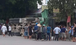 Xe chở đá bị lật nghiêng bên quốc lộ, đè sập nhà dân