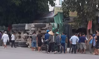 Xe chở đá bị lật nghiêng bên quốc lộ, đè sập nhà dân