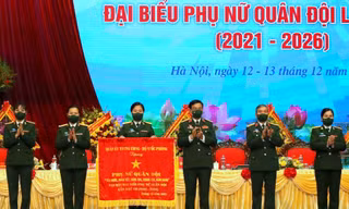 Đại tướng Phan Văn Giang, Ủy viên Bộ Chính trị, Phó Bí thư Quân ủy Trung ương, Bộ trưởng Bộ Quốc phòng trao tặng bức trướng 10 chữ vàng cho phụ nữ toàn quân. Ảnh: Nguyễn Minh 
