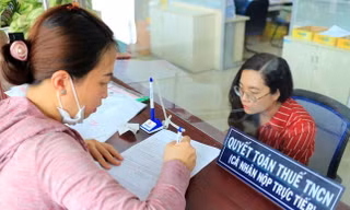 Người dân làm thủ tục quyết toán thuế thu nhập cá nhân tại cơ quan thuế. (Ảnh:NL). 