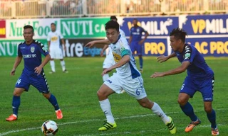 Lương Xuân Trường đi bóng giữa hai cầu thủ Bình Dương ở trận đấu chiều 10/3 trên sân Pleiku.