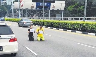 Cặp đôi quỳ gối giữa đường bất chấp xe cộ qua lại.