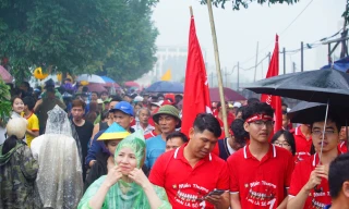 Đội mưa xem đua thuyền trên sông Pheo