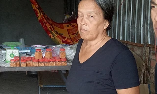 Bà ngoại của cháu L. cầm tấm hình của cháu mình đi tìm kiếm nhiều nơi