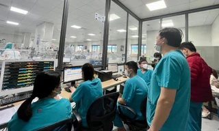 PGS.TS Hoàng Bùi Hải (ngoài cùng) quan sát nhân viên y tế làm việc trong phòng ICU Ảnh: Thái Hà 