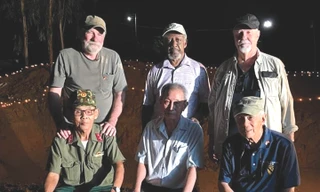 Ông Thụy - bên trái hàng trước - cùng những cựu binh Mỹ bên hố chôn liệt sĩ đồi Xuân Sơn Ảnh: NVCC 