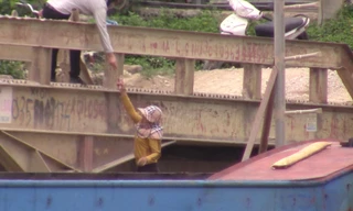 Chủ tàu (dưới) đưa tiền cho nhân viên cảng vụ tại khu vực Thanh Liêm (Hà Nam)