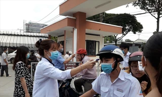 Các trường học ở TPHCM duy trì biện pháp đo thân nhiệt cho học sinh trước khi vào lớp. Ảnh chụp tại Trường THPT chuyên Nguyễn Hữu Huân (TP Thủ Đức). Ảnh: Huy Thịnh