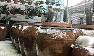 Anh Bùi Thanh Phú bên những lu mắm thành phẩm chuẩn bị xuất bán dịp Tết ảnh: Thái Lâm 