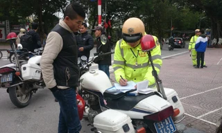 Lực lượng CSGT lập biên bản xử phạt người đi bộ.