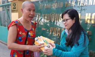 Một bệnh nhân vui mừng nhận bánh mì và sữa từ chương trình