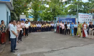 Học sinh và giáo viên trường tiểu học Hoàng Văn Thụ đứng tiễn thầy Khoa hiệu trưởng (ảnh báo PLVN)