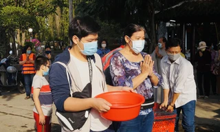 Người Sài Gòn đeo khẩu trang, thả cá chép đưa ông Táo về trời