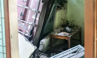 Thùng container lao khỏi xe đầu kéo, đâm sập tường nhà dân ven đường