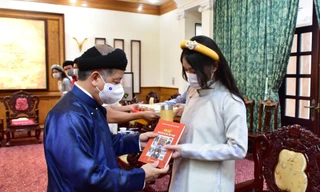 Chủ tịch Phan Ngọc Thọ tặng sách "Huế - Kinh đô áo dài Việt Nam" cho học sinh ghé tham quan trụ sở chính quyền tỉnh.