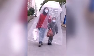 Hai mẹ con đeo khẩu trang và trùm túi nhựa kín mít chống virus corona