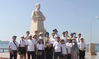 Du khách chụp ảnh bên tượng bác sĩ Yersin tại Nha Trang