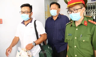 Công an Khánh Hoà dẫn giải ông Thái (áo đen, giữa) về nơi tạm giam. Ảnh LỮ HỒ