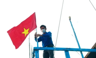 Thanh niên Khánh Hoà gắn cờ Tổ quốc lên tàu cá ngư dân
