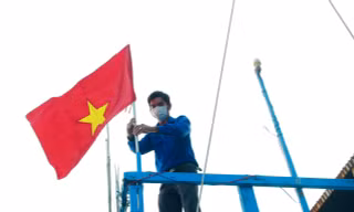 Thanh niên Khánh Hoà gắn cờ Tổ quốc lên tàu cá ngư dân