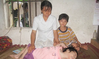 Chị Hương bên người con tật nguyền. Ảnh: D.Ng