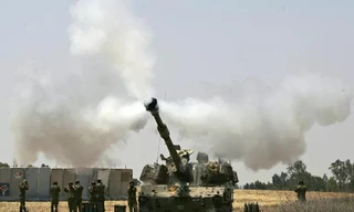 Một chiếc xe tăng của quân đội Israel bắn về phía Dải Gaza. Ảnh: AP