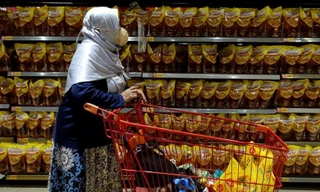 Một phụ nữ tìm mua dầu ăn trong siêu thị ở Indonesia ngày 27/3. Ảnh: Reuters