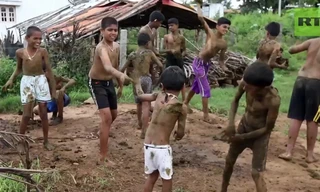 Những trẻ nhỏ tham gia lễ hội ném phân bò với nụ cười tươi trên khuôn mặt.