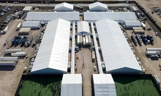 Những người di cư bị bắt vàđược nhìn thấy bên ngoài một trung tâm giam giữ sau khi cố gắng xâm nhập vào Mỹ, ở Donna, Texas.