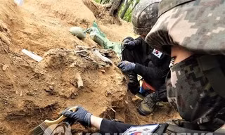 Các binh sĩ khai quật hài cốt được cho là của một binh sĩ Hàn Quốc thiệt mạng trong Chiến tranh Triều Tiên 1950-1953 tại Khu phi quân sự ở Cheorwon, tỉnh Gangwo. Ảnh: Yonhap