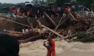 Thót tim người đàn ông ôm con đu dây qua nước lũ