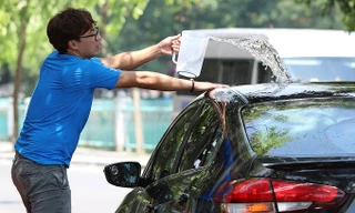 Trùm khăn kín người, dội nước 'tắm' ô tô trong nắng nóng 40 độ ở Hà Nội