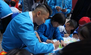 Một đại biểu thanh niên Việt Nam hướng dẫn trẻ khuyết tật tại trường Chuyên biệt Bình Minh, Đông Anh vẽ tranh. Ảnh: Thanh Huyền