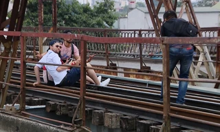 Du khách ngồi trên đường ray cầu Long Biên chụp ảnh