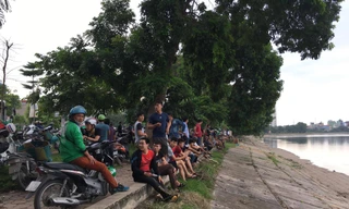 Nhiều người dân tập trung ven hồ theo dõi sự việc.