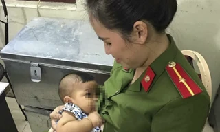 Bé trai đang được cán bộ công an phường chăm sóc.