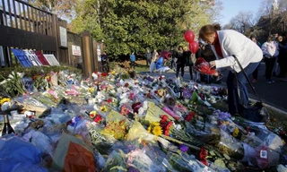 Một phụ nữ đặt hoa tưởng niệm các nạn nhân vụ khủng bố Paris trước cổng đại sứ quán Pháp ở Washington, Mỹ