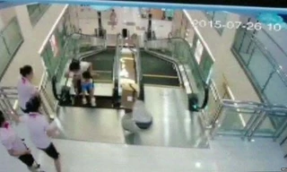 Người mẹ đang dắt con nhỏ đi trên thang cuốn thì tấm kim loại phía trên cùng bị sập xuống.